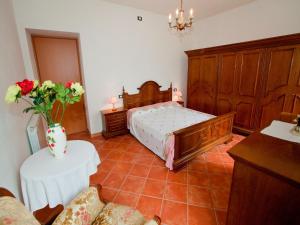 une chambre avec un lit et une table avec un vase de fleurs dans l'établissement Spacious home surrounded by nature, à Sesta Godano