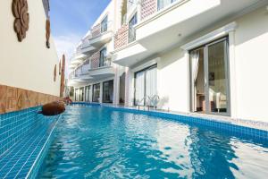 a swimming pool in front of a building at Chăm Charm Mũi Né, Phan Thiết in Mui Ne
