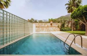 une piscine dans une arrière-cour avec un mur en pierre dans l'établissement Mete 2 Villa İcmeler Marmaris, à İçmeler