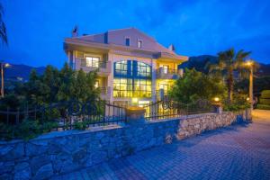 une grande maison sur un mur de pierre la nuit dans l'établissement Mete 2 Villa İcmeler Marmaris, à İçmeler