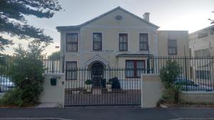 een oud huis met een hek ervoor bij The Wellstead in Wynberg