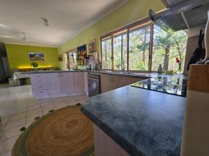 eine Küche mit gelben Wänden und einer großen Arbeitsplatte in der Unterkunft Gold Coast Hinterland Experience No ppl 8 in Tallebudgera + 21 Fotos