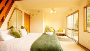 een slaapkamer met een groot bed met een groot raam bij Ora Springs Retreat 