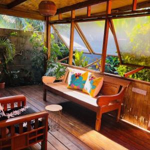 eine Veranda mit einer Bank auf einem Holzdeck in der Unterkunft Fare Miriau in Papara