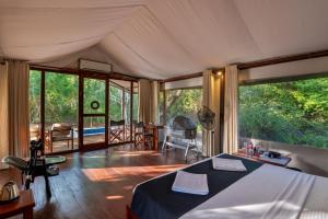 een slaapkamer met een bed in een kamer met ramen bij Wild Trails Yala by Suri in Yala