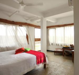 ein Schlafzimmer mit einem Bett mit einer roten Decke darauf in der Unterkunft 36 Palms Boutique Retreat in Cherai Beach + 84 Fotos