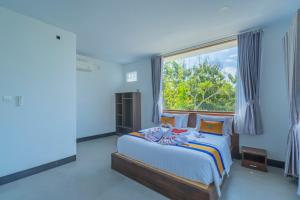 ein Schlafzimmer mit einem Bett mit einem großen Fenster in der Unterkunft Govardhan Nusa Penida in Nusa Penida