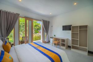 ein Schlafzimmer mit Bett, Schreibtisch und Fenster in der Unterkunft Govardhan Nusa Penida in Nusa Penida