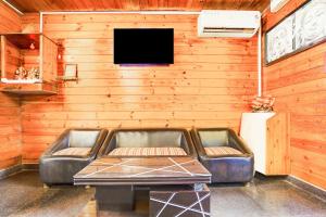 een woonkamer met een leren bank en een tv bij Townhouse Morjim in Goa