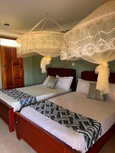 deux lits côte à côte dans une pièce dans l'établissement Mufasha Boutique Suites, à Kisoro