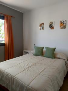 una camera da letto con un grande letto bianco con cuscini verdi di El gran nogal colon a Colón