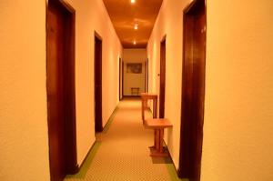 a corridor of a hallway with a table and a bench at Hotel Lincoln in Villa Gesell