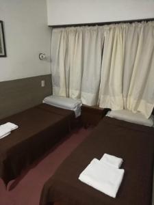 a hotel room with two beds and a window at Hotel Lincoln in Villa Gesell