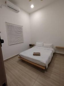 a bedroom with a bed in a white room at Bayu Beach House in Cherating