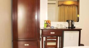 een kamer met een houten bureau met een wastafel en een spiegel bij Devera Hotel in Angeles