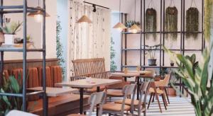 ein Restaurant mit Tischen, Stühlen und Pflanzen in der Unterkunft Fun Hotel in Ban Thai Wat Khot