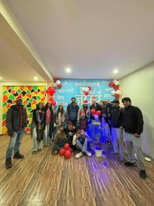 a group of people standing in a room with balloons at The Pink Nest - Backpackers Abode in Jaipur