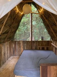 eine Matratze in einem Zelt mit einem großen Fenster in der Unterkunft Serene and peaceful farmstay near Xaibe in Corozal