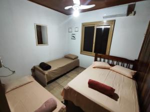 ein Schlafzimmer mit zwei Betten und einer Couch und einem Fenster in der Unterkunft La Casa de la Esquina en el Centro in São Gabriel