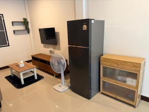 un frigorifero nero in una stanza con un ventilatore di Baan Airport 2 a Ban Wat Pho Thong