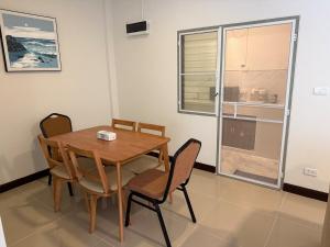 una sala da pranzo con tavolo e sedie in legno di Baan Airport 2 a Ban Wat Pho Thong Altre 18 foto