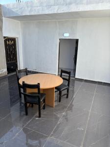a wooden table and two chairs in a room at Golden Stay in Jerash