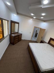 a bedroom with a bed and a dresser and a mirror at Golden Stay in Jerash +7 photos