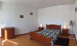 ein Schlafzimmer mit einem Bett, zwei Kommoden und zwei Lampen in der Unterkunft Residencias Varadouro in Varadouro