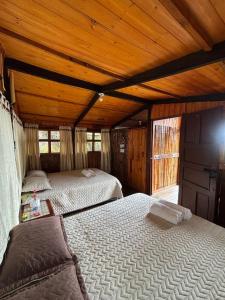 two beds in a room with wooden ceilings at Entre Rocas y Cristales in Ráquira +63 photos