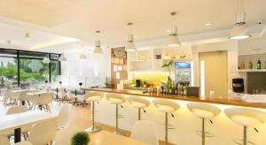 een keuken met een bar met witte krukken bij Venue 88 in Dulongabong