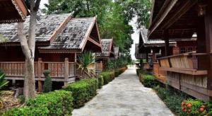 een wandelpad voor enkele gebouwen met bomen bij Little Home Beach in Ban Khok Rak