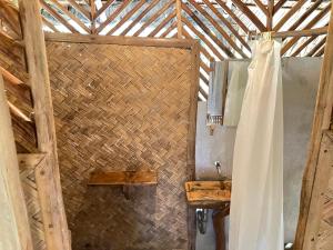 a bathroom with a sink and a wooden wall at Backpacker's Hill Resort in San Vicente