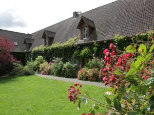 een huis met een tuin met bloemen in de tuin bij Charming Chalet with Swimming Pool in Quend in Quend
