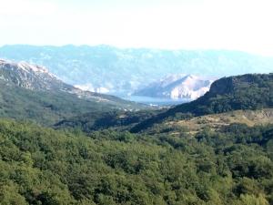a view of a valley with a lake and mountains at Apartments u Kapetana in Punat