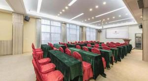 une salle de conférence avec des chaises rouges et un écran dans l'établissement Fortune Hotel Ningde, à Ningde