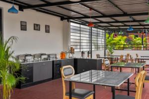 una cucina e una sala da pranzo con tavoli e sedie di Wandr Hotel Richmond Road a Bangalore