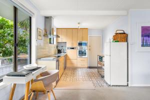 a kitchen with a refrigerator and a table and chairs at Tide & Timber - Adventure Bay in Adventure Bay