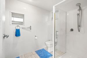 een witte badkamer met douche en toilet bij Tide & Timber - Adventure Bay in Adventure Bay +21 foto's