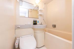 a bathroom with a toilet and a sink and a tub at Ace Inn Matsumoto in Matsumoto