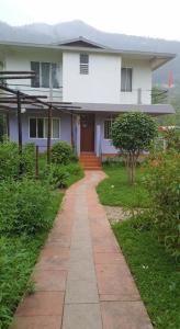 a white house with a pathway in front of it at Sayatri stay in Karsiyang