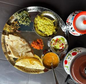 a table with a plate of food with different types of food at HEMGIRI - Private Pool Villa Mulshi in Mulshi