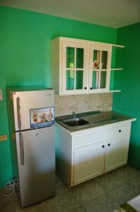 a kitchen with a refrigerator and a sink at Paradise on the Rocks in Negril