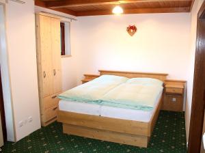 ein Schlafzimmer mit einem Bett mit einem Holzrahmen in der Unterkunft Apartments at Berghaus Glockner in Heiligenblut