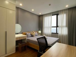 a bedroom with a bed and a desk and a table at QMP - Vinhomes D'Capitale Tran Duy Hung in Hanoi +70 photos