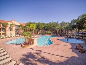a swimming pool at a resort with chairs and trees at Blue Tree Resort at Lake Buena Vista in Orlando