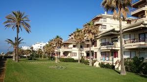 a large apartment building with palm trees in front of it at Sol y Relax, Lubina Sol in Mijas Costa