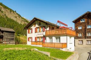 ein Haus mit einem Balkon an der Seite in der Unterkunft Abendstern in Saas-Almagell