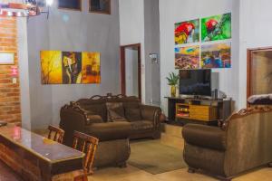 un soggiorno con due divani e una TV di Casa de Campo San Isidro a Rovine di Copán