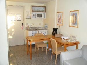 uma cozinha com uma mesa de madeira e cadeiras num quarto em Fortaleza 703--Fortaleza 713 em Fortaleza