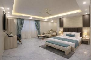 una camera da letto con un letto grande e un divano di Hotel Ginger Palace Delhi Airport With Free Airport Pic Or Drop a Nuova Delhi Altre 125 foto
